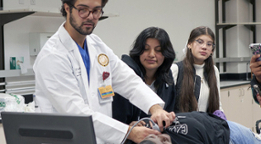 medical student demonstrating ultrasound to high school students