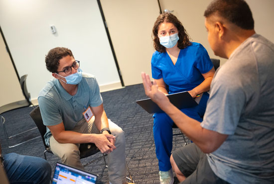 translator and medical student listening to patient talk during exam