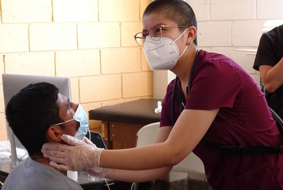 female student wearing a mask checking on male patient