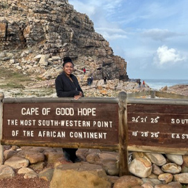 Student standing by "Cape of Good  Hope" sign