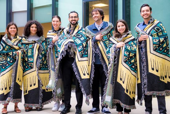 group photo of students wrapped in blankets at indigenous medicine ceremony