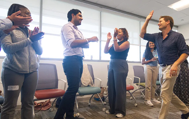 Group of students smiling and clapping