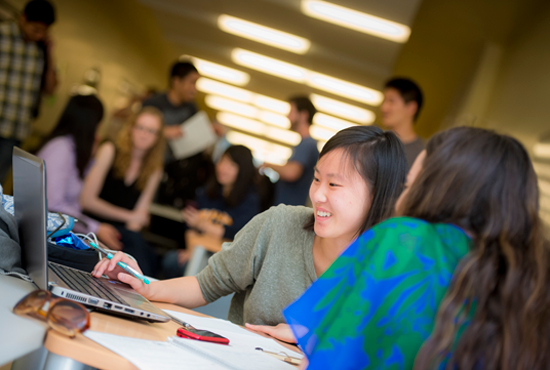 Two students smiling and collaborating