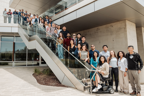 large group of people standing along a concrete staircase outside