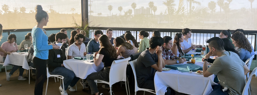 2 of 11, Large group of people dining outdoors on a patio at sunset