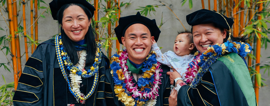 10 of 13, Group of students in graduation regalia smiling at camera