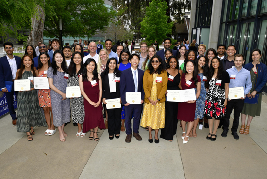 Group of 4th year medical students smiling holding award certificates