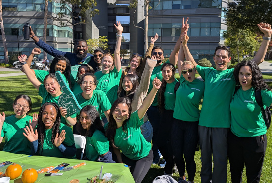 Group of students all wearing green T-shirt smiling and laughing